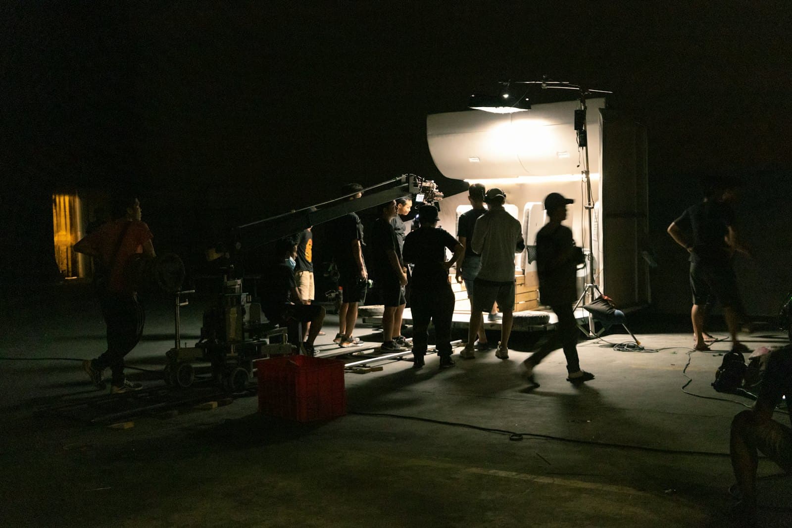 Une équipe de tournage réunie autour d’une caméra, de nuit, en extérieur.